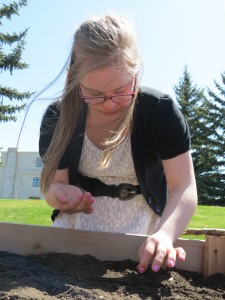 Morgan plants some lettuce in the DDRC's garden plot.