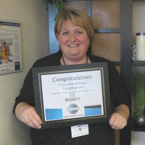 Crysta Trask holds a certificate presented by area and district directors from Toastmasters.