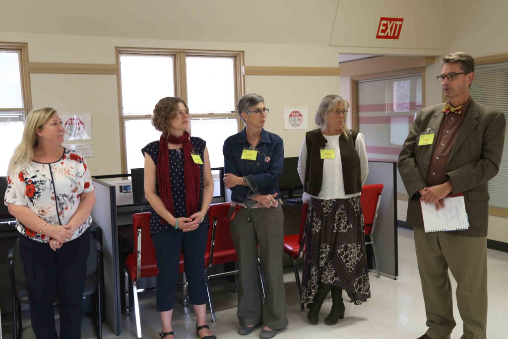 CEO Helen Cowie and Bow Valley College employees listen to Keith Seel (Dean of the Centre for Excellence in Foundational Learning).