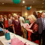 A crowd gathers around the silent auction tables.