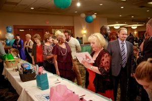 A crowd gathers around the silent auction tables.